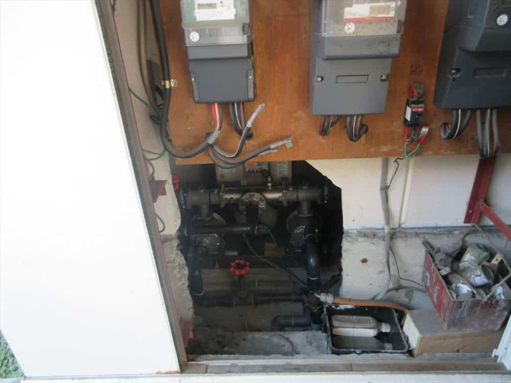 奥まった場所に設置されている増圧給水ポンプの写真