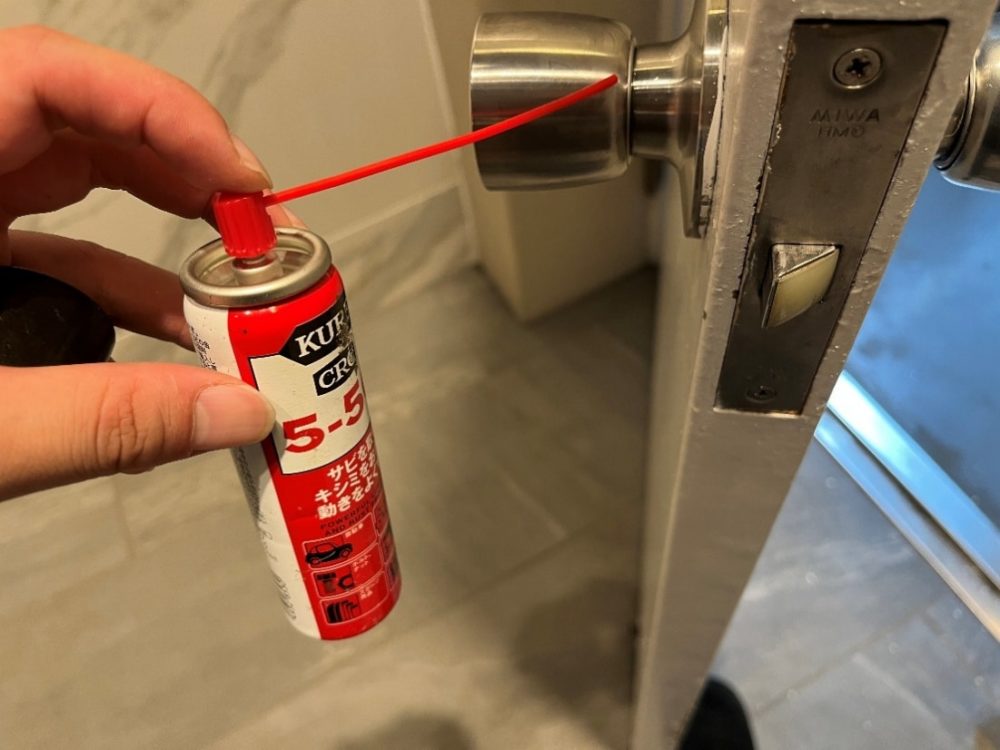 ドアノブに潤滑剤を差している画像