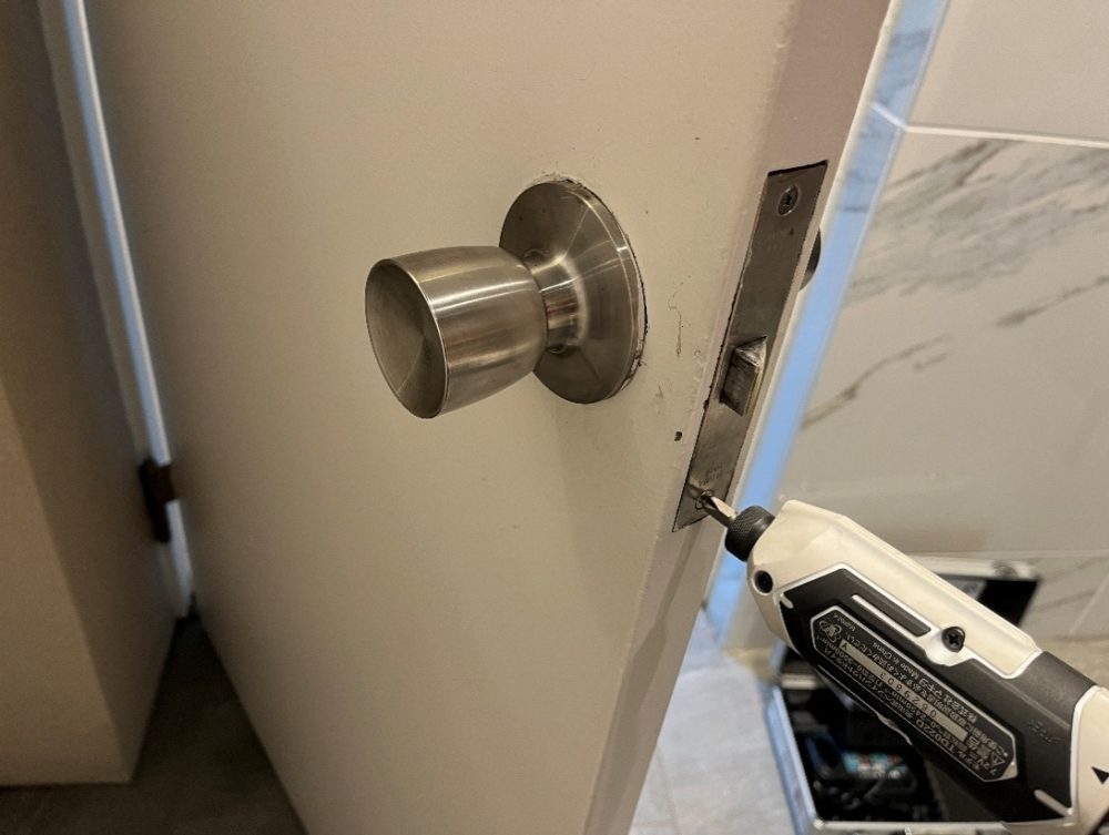 工具を使ってネジを締め直している画像